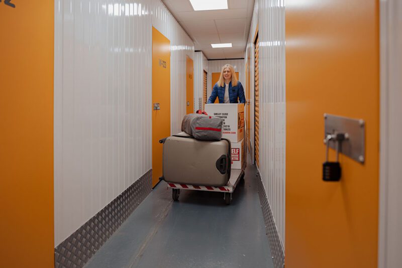 woman putting her personal things inside her personal self storage room